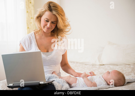 Caucasian mother with baby using laptop Stock Photo