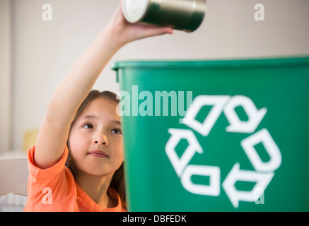 Mixed race girl recycling can Stock Photo