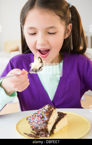 Mixed race girl eating cake Stock Photo
