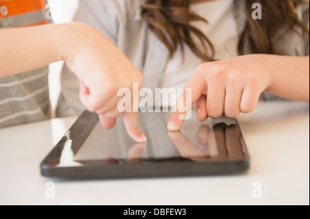 Hispanic girl using tablet computer on desk Stock Photo