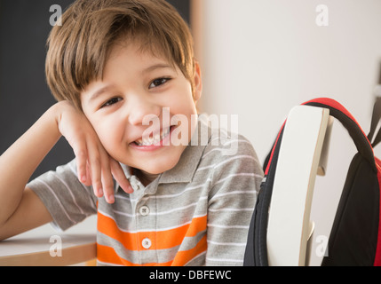 Hispanic boy smiling at desk Stock Photo