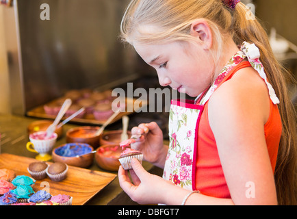 Caucasian girl making cupcakes Stock Photo