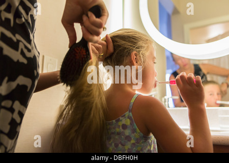 Caucasian mother brushing daughter's hair Stock Photo