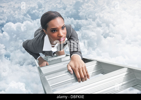 African American businesswoman climbing ladder Stock Photo