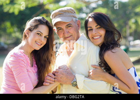 Hispanic father and daughters smiling outdoors Stock Photo