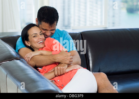 Hispanic couple relaxing on sofa Stock Photo