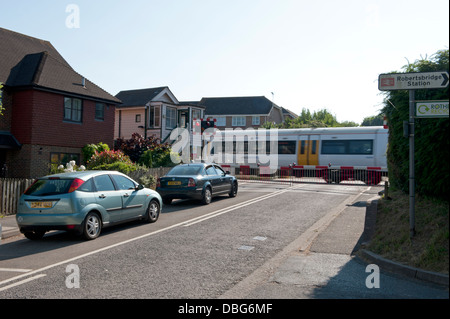 Traffic stopped at a barrier railway crossing in Sussex, UK Stock Photo