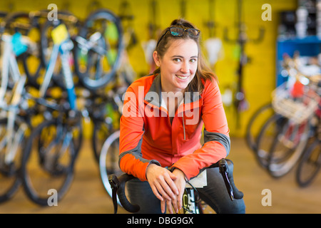 Caucasian woman sitting in bicycle shop Stock Photo