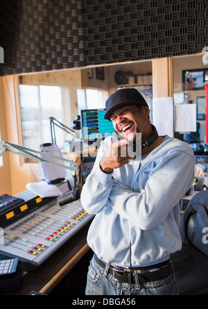 Mixed race disc jockey smiling in studio Stock Photo