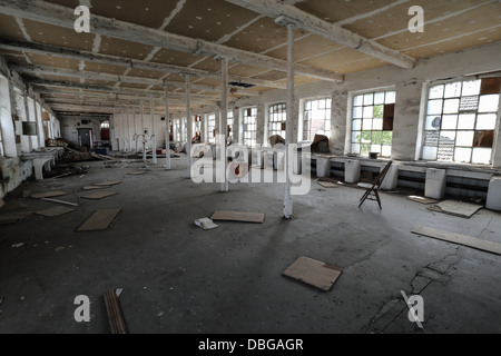 Abandoned factory with broken stuffs on the ground like chairs and wood panels. nobody. Stock Photo