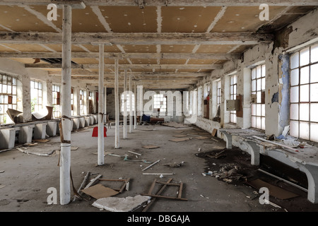 Abandoned factory with broken stuffs on the ground like chairs and wood panels. nobody. Stock Photo