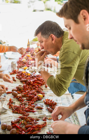 Caucasian men eating at crawfish boil Stock Photo