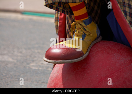 Clown entertaining the crowds for Swanage Carnival Procession, Swanage, Dorset UK in July - close up of clown shoe on ball Stock Photo