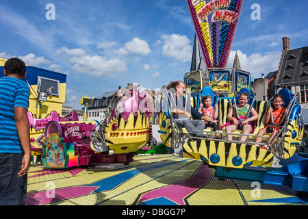 Father with children visiting fairground attraction at traveling funfair / travelling fun fair Stock Photo