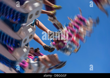 Excited thrillseekers / thrill seekers having fun on the fairground attraction G Force at travelling funfair / traveling fair Stock Photo
