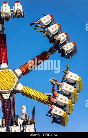 Excited thrillseekers / thrill seekers having fun on fairground attraction G Force at travelling funfair / traveling fun fair Stock Photo