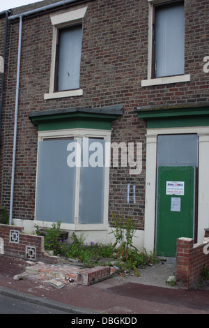 Front of a boarded up house waiting to be demolished, Salem St South, Hendon Sunderland. The front garden wall has collapsed. Stock Photo