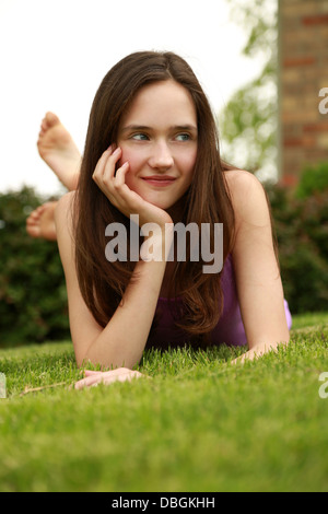 brunette tween girl laying on stomach Stock Photo