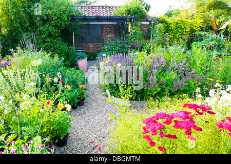 Typical English garden plants flowers planted around path Stock Photo