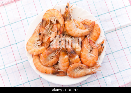 Pile of prepared shrimps lays on round white plate Stock Photo