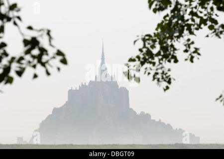 Misty silhouette of Mont Saint-Michel (Saint Michael's Mount) seen across surrounding countryside, Basse-Normandie (Lower Normandy), France