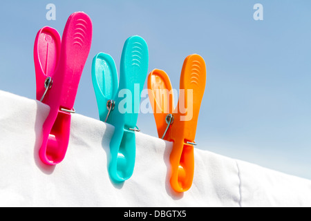 Three clothes pegs on a line Stock Photo