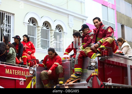 Voluntary firefighters sitting on a fire truck on the Wong Parade on July 21, 2013 in the district of Miraflores, Lima, Peru. Stock Photo