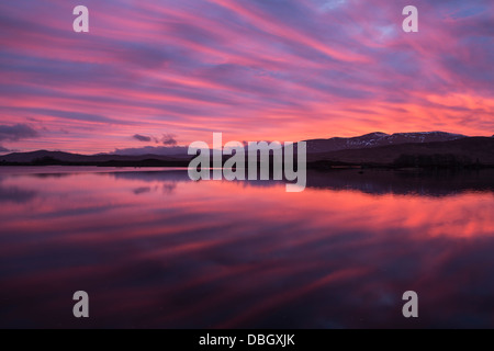 Spectacular pink sunrise reflection on Loch Ba, Rannoch Moor, Highland, Scotland