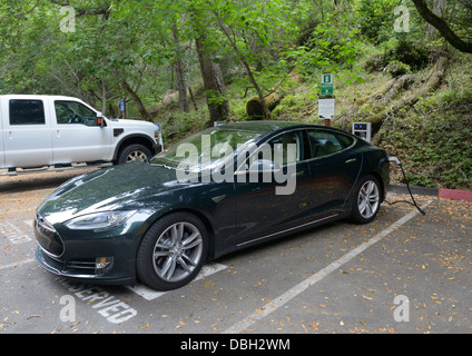 Electric car charging station with a Tesla sedan plugged in.  See description for details Stock Photo