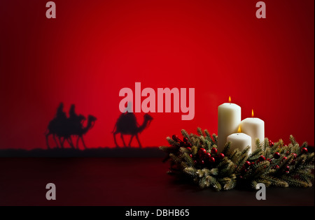 Three wise men on the way to Jesus in Bethlehem and candles Stock Photo