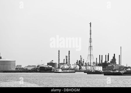 Distillation towers and oil storage tanks in a refinery during daytime, black and white shot. Stock Photo