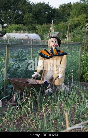 Scarecrow with wheelbarrow in urban allotment Stock Photo