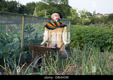 Scarecrow with wheelbarrow in urban allotment Stock Photo