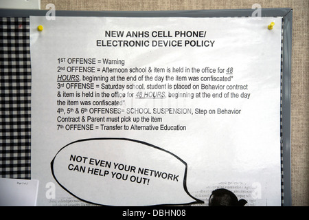 A sign on a suburban high school wall in Aliso Viejo, CA, lists escalating penalties for unauthorized use of cell phones Stock Photo