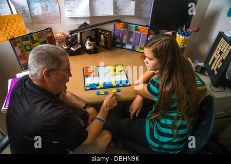 A certified dyslexia testing specialist in a home office uses colored tile manipulation for a multisensory approach to spelling Stock Photo