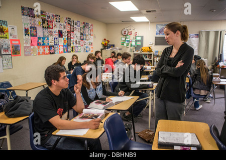 California high school English teacher assists her students comprehension during a reading exercise using a literary anthology Stock Photo