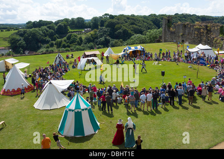 Crowd watching two knights in armour in an historical Medieval  Tournament re-enactment demonstrating sword fighting on foot Stock Photo