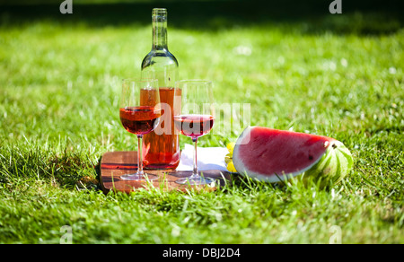 Wine and picnic basket on the grass Stock Photo