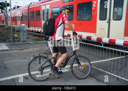 Cyclist at railway level crossing in Leichlingen Germany Stock Photo