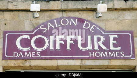 Traditional sign above a hairdresser's shop in the French town of Florac, Lozere. Stock Photo