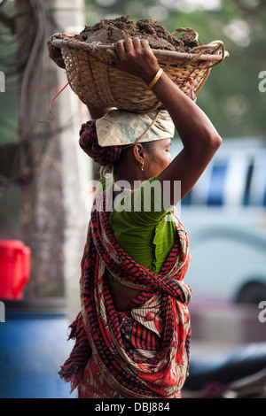 Rural Bangladeshi women perform manual labor carrying dirt for three dollars $3 a day on a road project in Chittagong Bangladesh Stock Photo