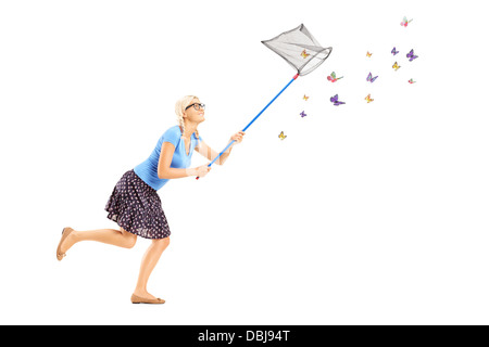 Full length portrait of a woman running and catching butterflies with net isolated on white background Stock Photo