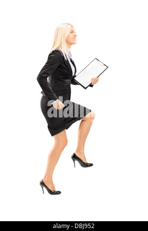 Full length portrait of a young businesswoman doing a huge step towards isolated on white background Stock Photo