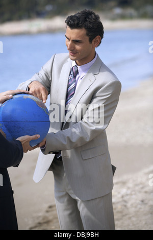 Businessmen hands grasping the globe Stock Photo