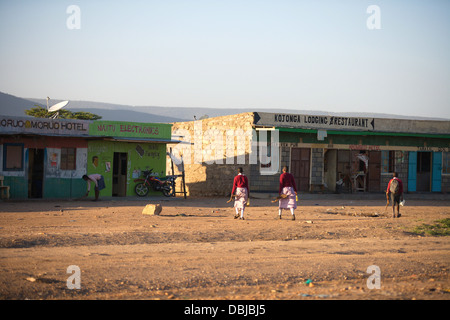 Masai people walking through a town just outside of the Masai Mara National Reserve. Kenya, Africa. Stock Photo