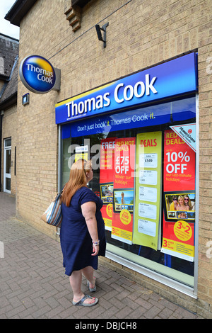 Woman looking in window of Thomas Cook travel agent, Alvescot Road, Carterton, Oxfordshire, England, United Kingdom Stock Photo