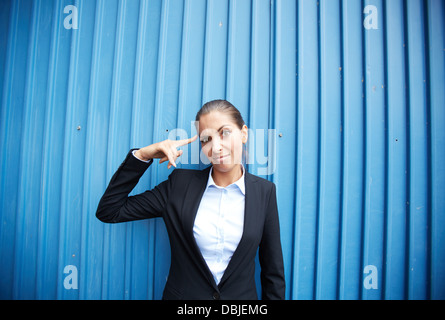 Image of young businesswoman standing by blue wall Stock Photo