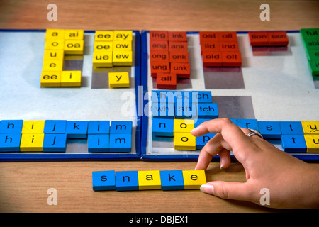 A certified dyslexia testing specialist in a home office uses colored tile manipulation for a multisensory approach to spelling Stock Photo