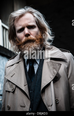 Portrait of a bearded business man in suit and overcoat. Stock Photo