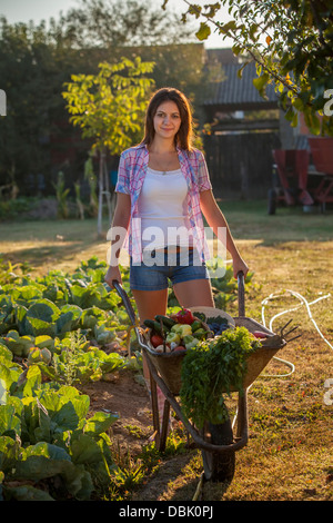 Portrait woman pushing wheelbarrow garden Stock Photo - Alamy